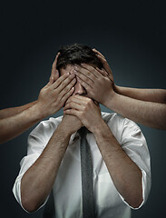 Image showing A young man surrounded by hands like his own thoughts