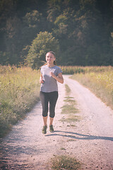 Image showing woman jogging along a country road