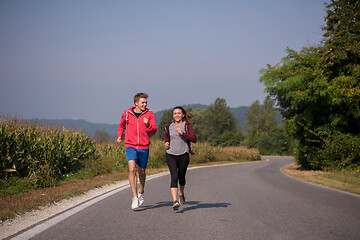 Image showing young couple jogging along a country road