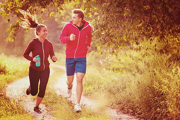 Image showing young couple jogging along a country road