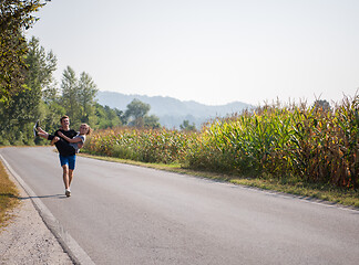 Image showing happy couple jogging along a country road