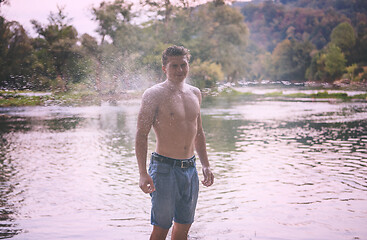 Image showing man with a bare torso splashing water