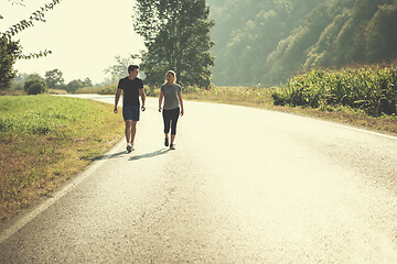 Image showing young couple jogging along a country road