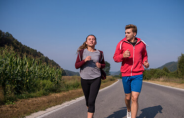 Image showing young couple jogging along a country road