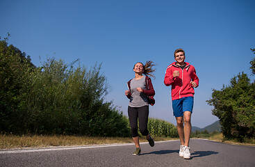 Image showing young couple jogging along a country road