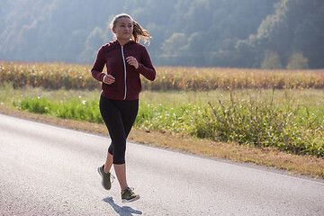 Image showing woman jogging along a country road