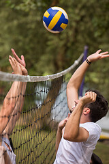 Image showing group of young friends playing Beach volleyball