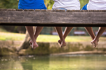 Image showing people sitting at wooden bridge