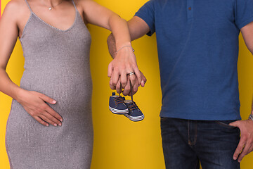 Image showing couple holding newborn baby shoes