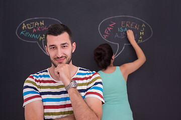 Image showing pregnant couple writing on a black chalkboard