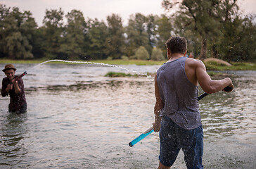 Image showing young men having fun with water guns