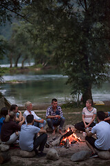 Image showing young friends relaxing around campfire