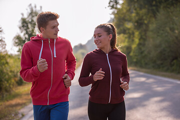 Image showing young couple jogging along a country road