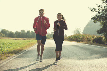 Image showing young couple jogging along a country road