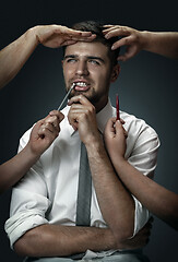 Image showing A young man surrounded by hands like his own thoughts