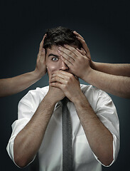 Image showing A young man surrounded by hands like his own thoughts