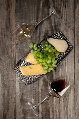 Image showing A bottle and glasses of red and white wine with fruits