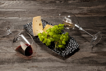 Image showing A bottle and glasses of red and white wine with fruits