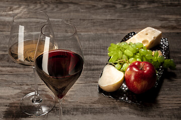 Image showing A bottle and glasses of red and white wine with fruits
