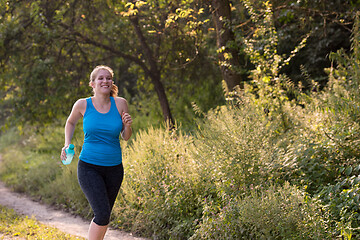 Image showing woman jogging along a country road