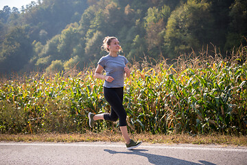 Image showing woman jogging along a country road