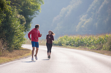 Image showing young couple jogging along a country road