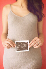 Image showing happy pregnant woman showing ultrasound picture