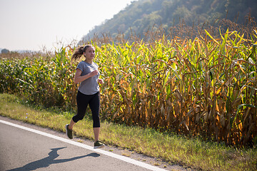 Image showing woman jogging along a country road