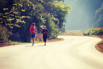 Image showing young couple jogging along a country road