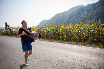 Image showing happy couple jogging along a country road