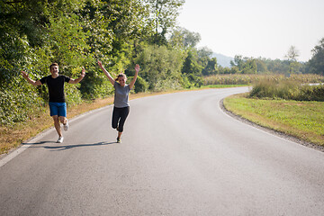 Image showing young couple jogging along a country road