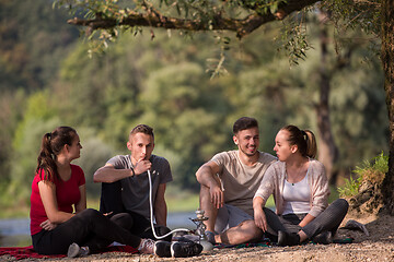 Image showing friends smoking hookah on the river bank
