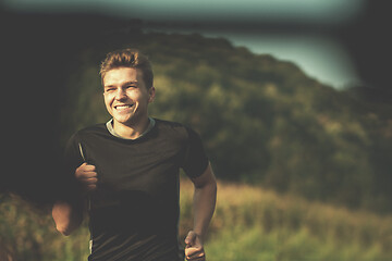 Image showing man jogging along a country road