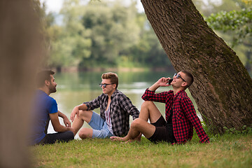 Image showing men sitting on the bank of the river