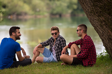 Image showing men sitting on the bank of the river