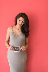 Image showing happy pregnant woman showing ultrasound picture