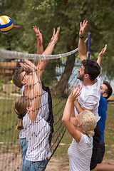 Image showing group of young friends playing Beach volleyball