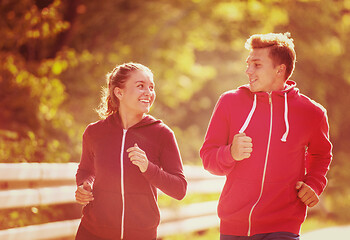 Image showing young couple jogging along a country road