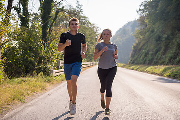 Image showing young couple jogging along a country road