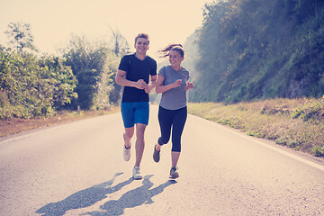 Image showing young couple jogging along a country road