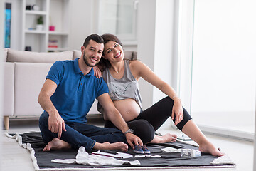 Image showing pregnant couple checking a list of things for their unborn baby