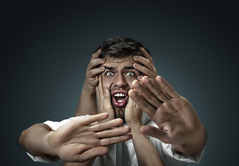 Image showing A young man surrounded by hands like his own thoughts