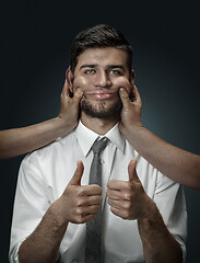 Image showing A young man surrounded by hands like his own thoughts