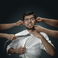 Image showing A young man surrounded by hands like his own thoughts