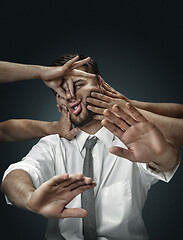 Image showing A young man surrounded by hands like his own thoughts