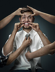 Image showing A young man surrounded by hands like his own thoughts