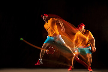 Image showing One caucasian man playing tennis on black background