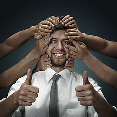 Image showing A young man surrounded by hands like his own thoughts