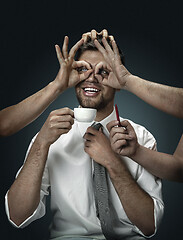 Image showing A young man surrounded by hands like his own thoughts