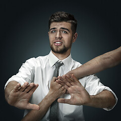 Image showing A young man surrounded by hands like his own thoughts